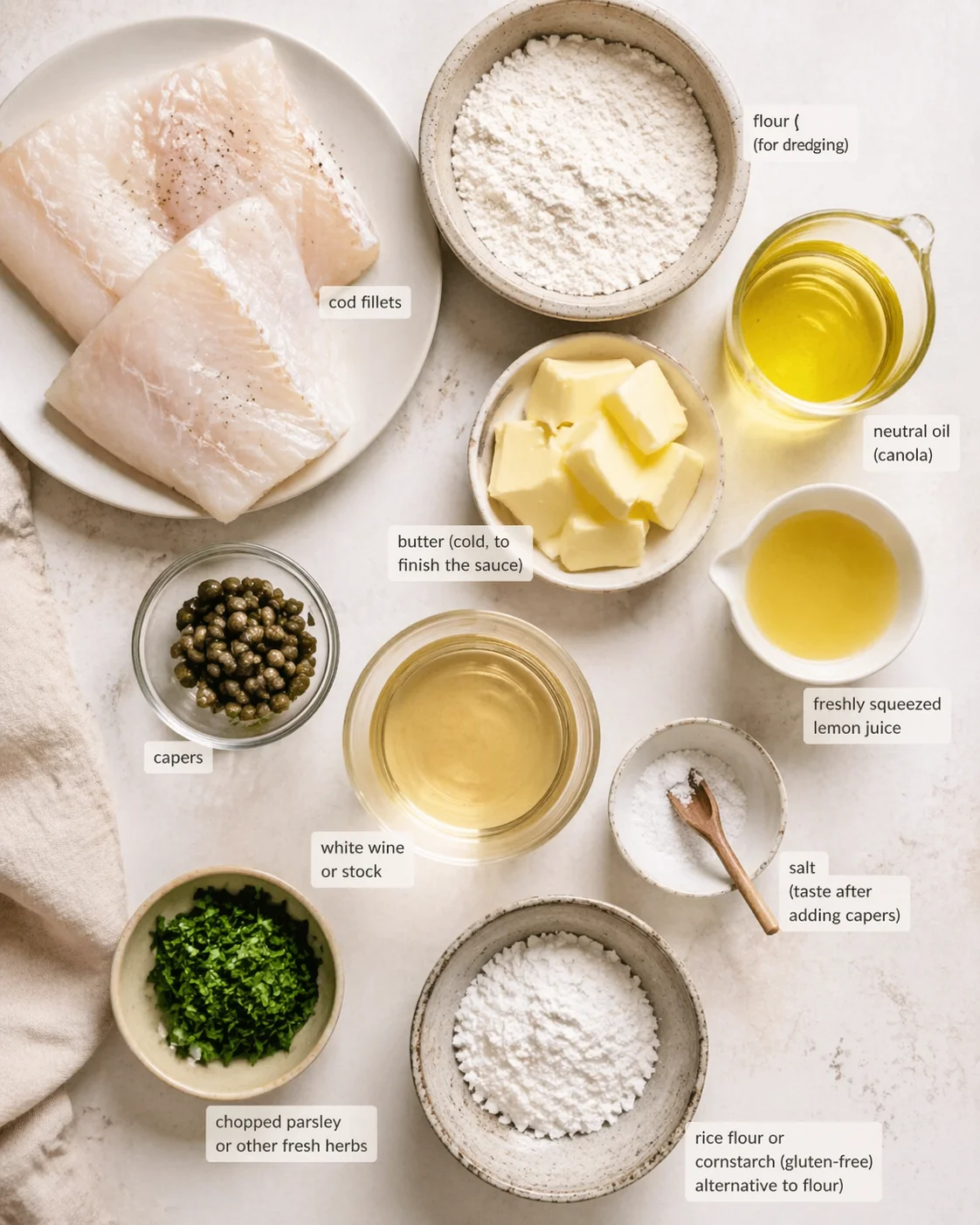 Overhead shot of labeled ingredients for a cod dish arranged on a light countertop.