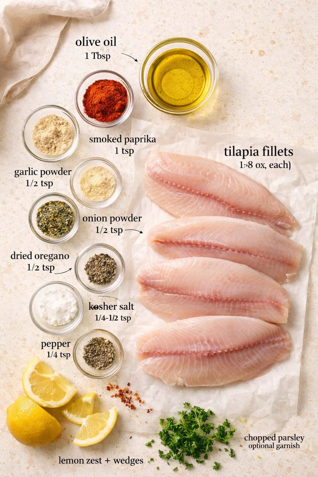 raw tilapia fillets with spice bowls, lemon wedges and parsley on parchment