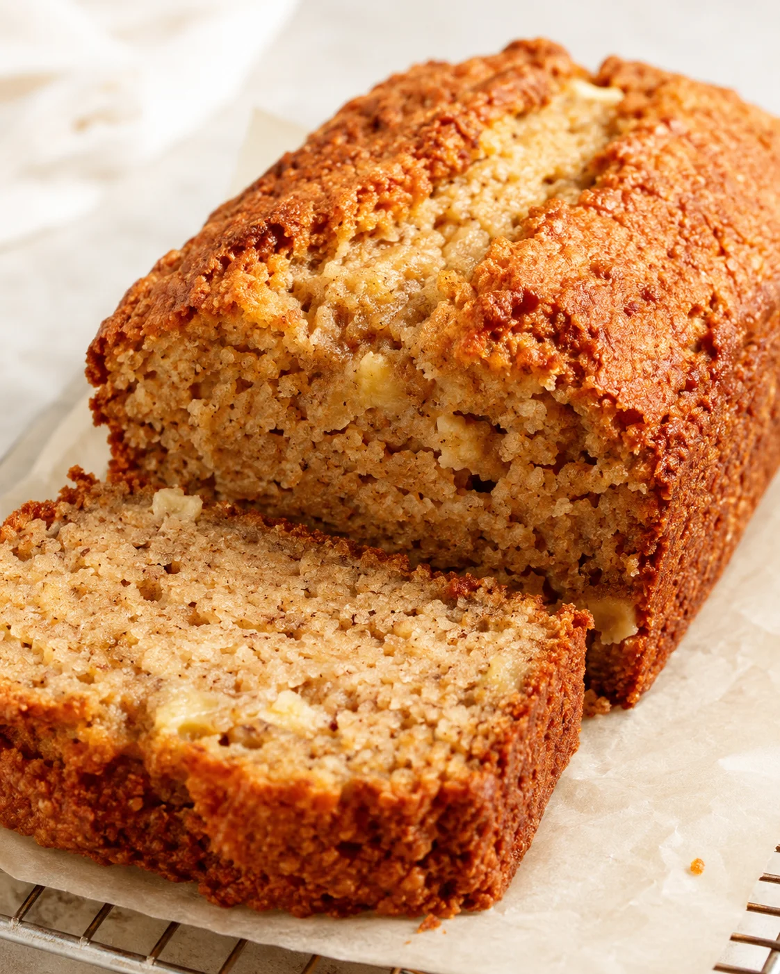 Moist banana bread loaf with golden crust, sliced to show tender crumb.