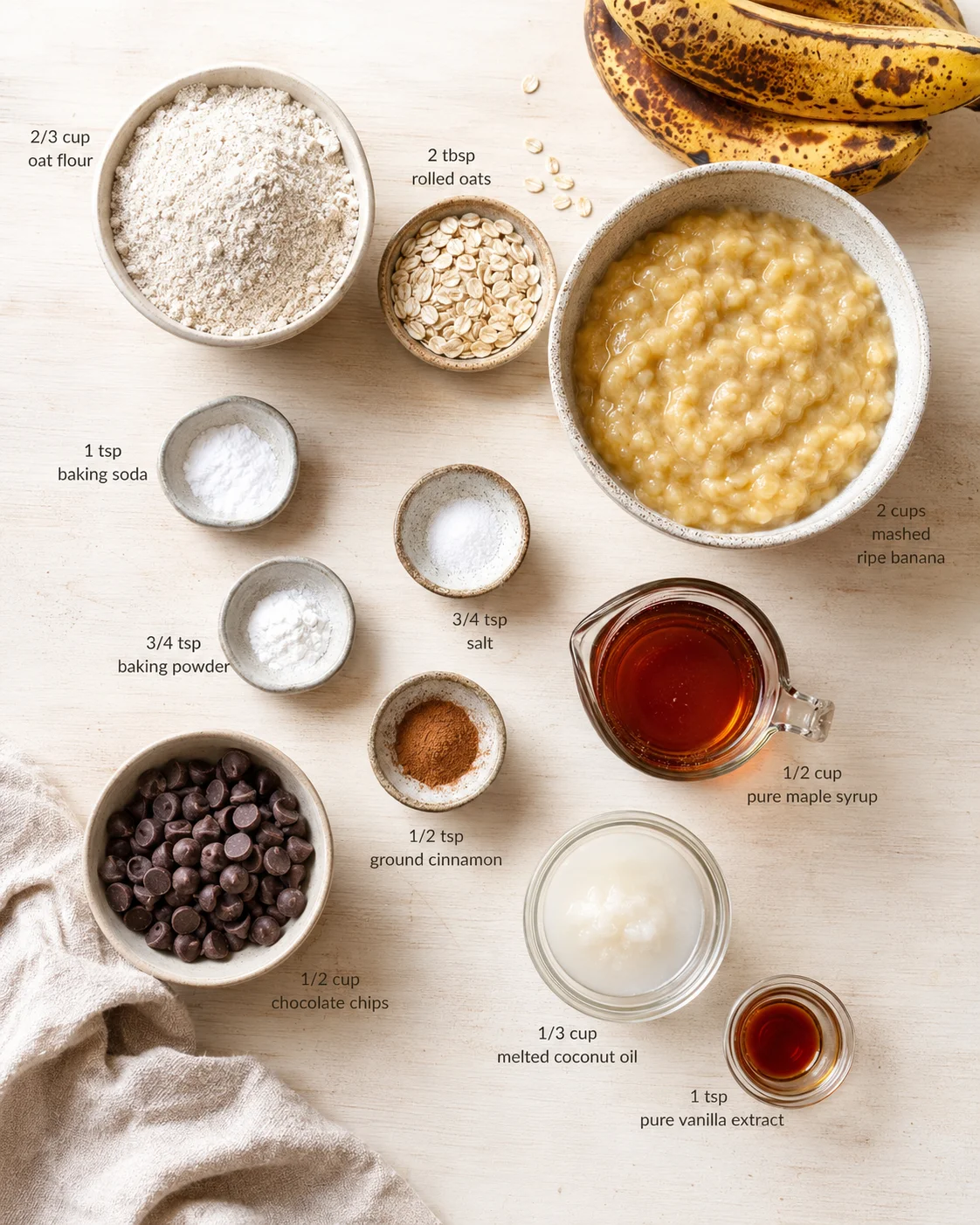 overhead view of labeled baking ingredients for banana oat bake on a light wood surface