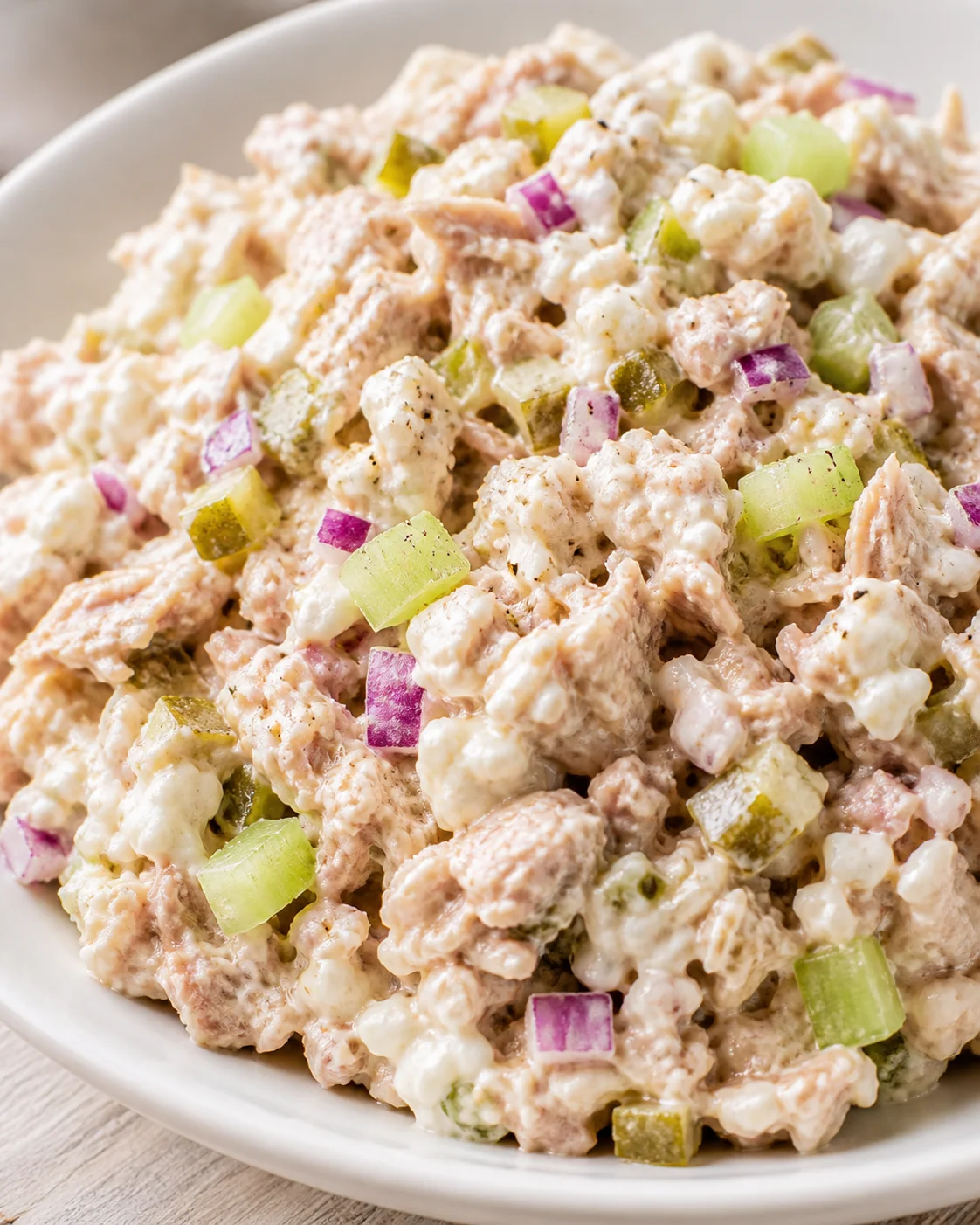 bowl of creamy chicken salad with diced celery and red onion