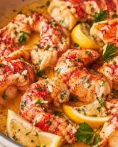 Succulent shrimp in lemon-butter sauce, garnished with parsley, in a skillet.