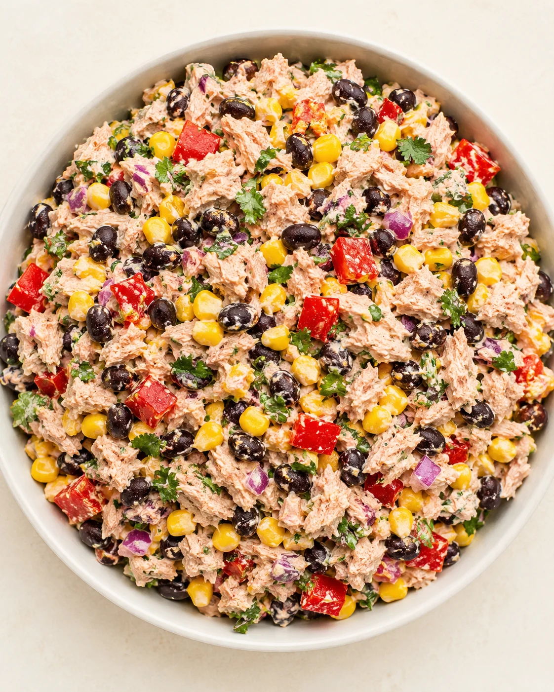 Overhead view of a bowl of tuna salad with corn, black beans, peppers, and cilantro.