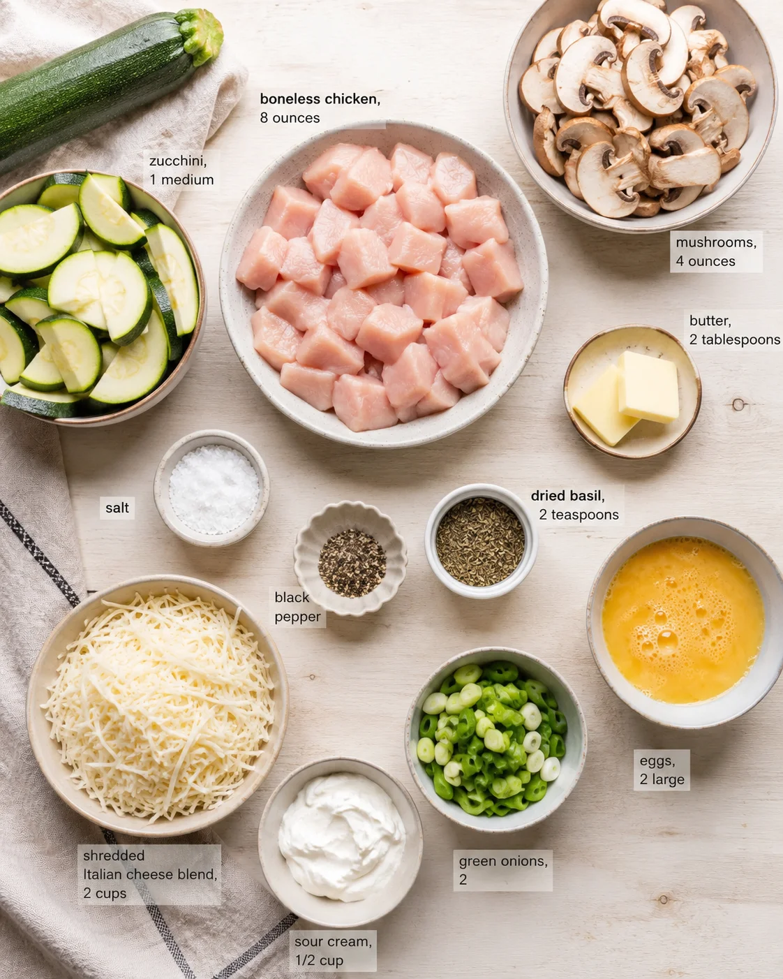 flat lay of labeled ingredients for chicken dish with bowls on a light wooden surface