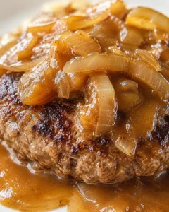 Close-up of a caramelized onion-topped hamburger patty in glossy brown gravy