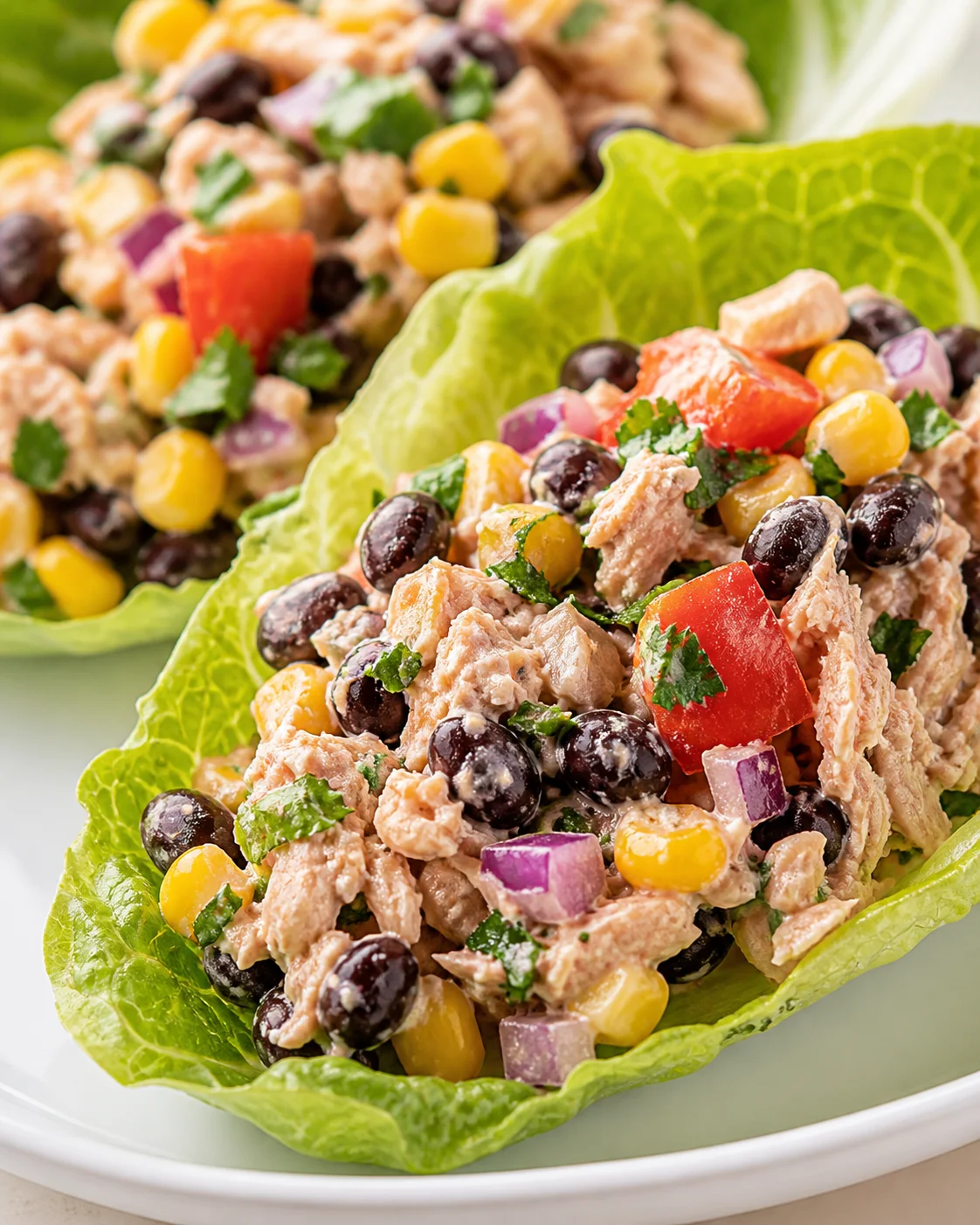 Fresh tuna salad in lettuce cups with corn, olives, red onion, and peppers