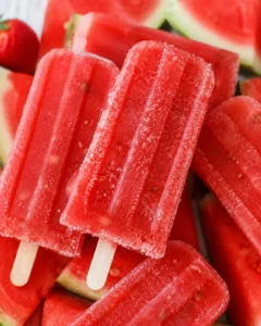 Close-up of vibrant homemade strawberry watermelon popsicles with wooden sticks