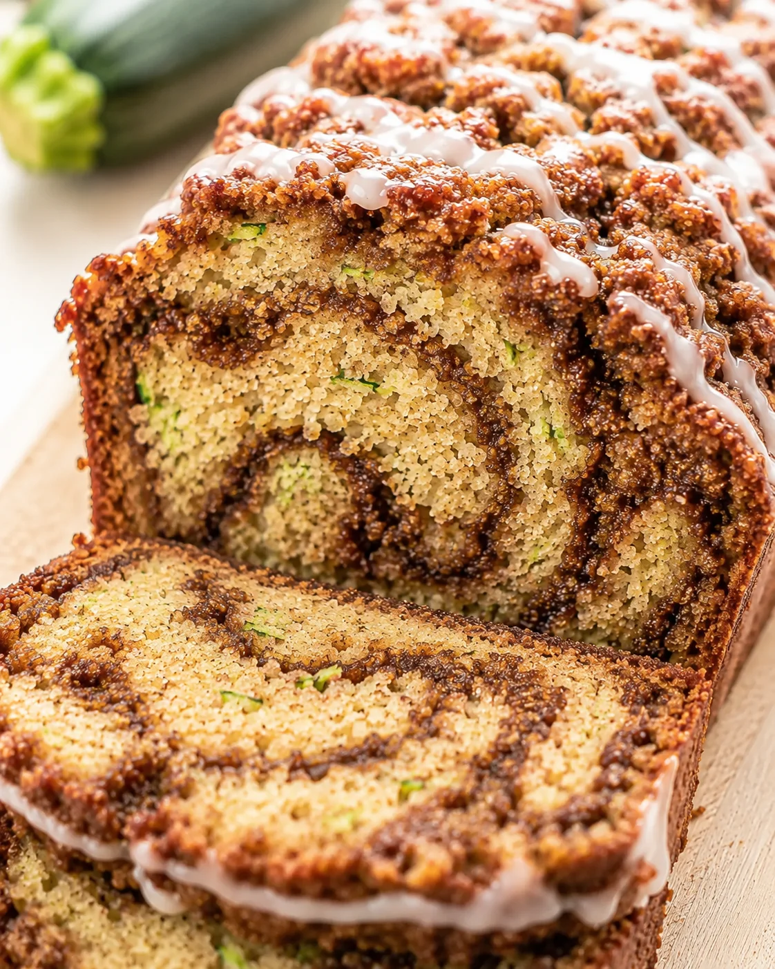 Moist Cinnamon Swirl Zucchini Bread Close-up of freshly baked cinnamon swirl zucchini bread with drizzle on top.