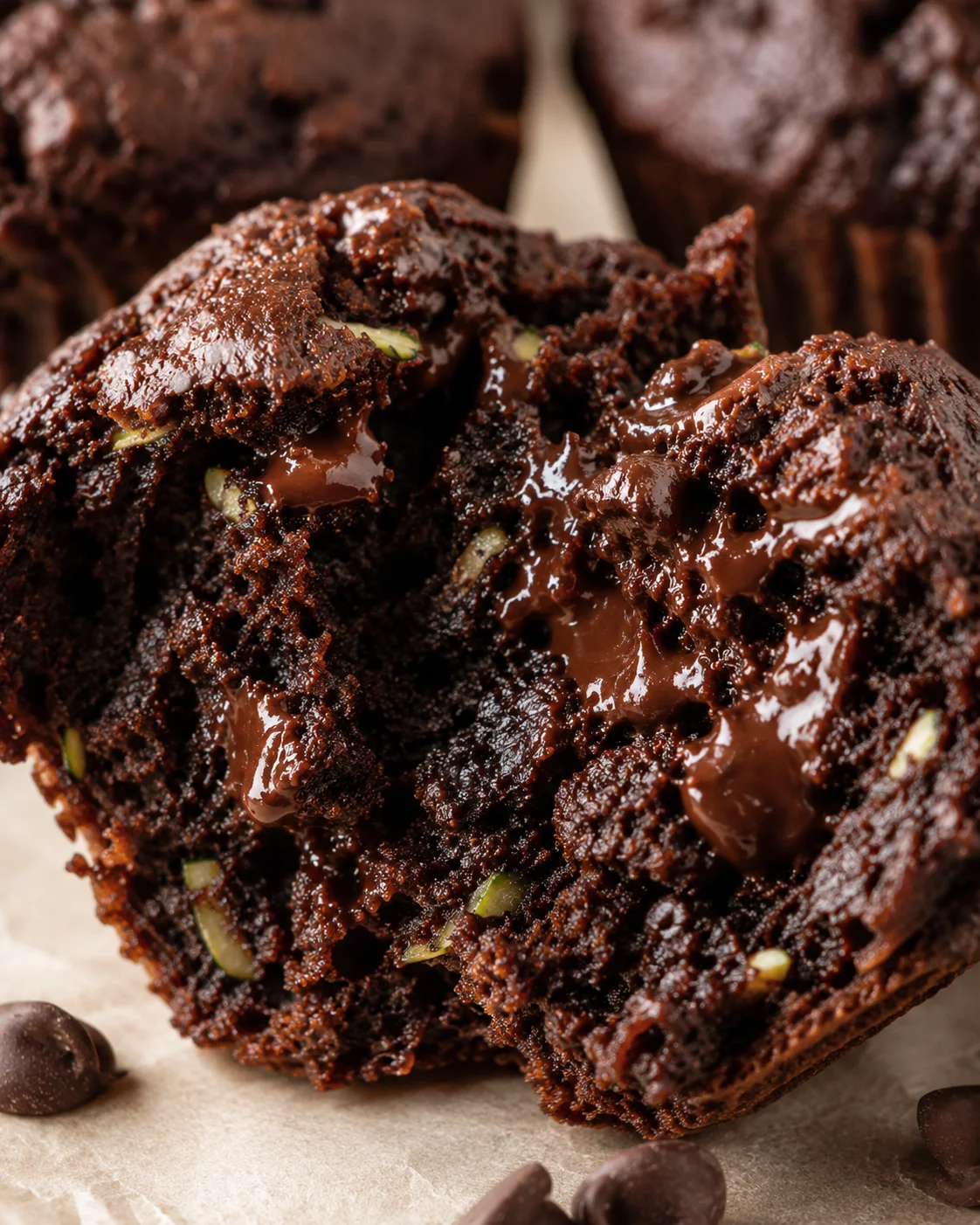 Close-up of moist, chocolatey zucchini muffins filled with chocolate chips