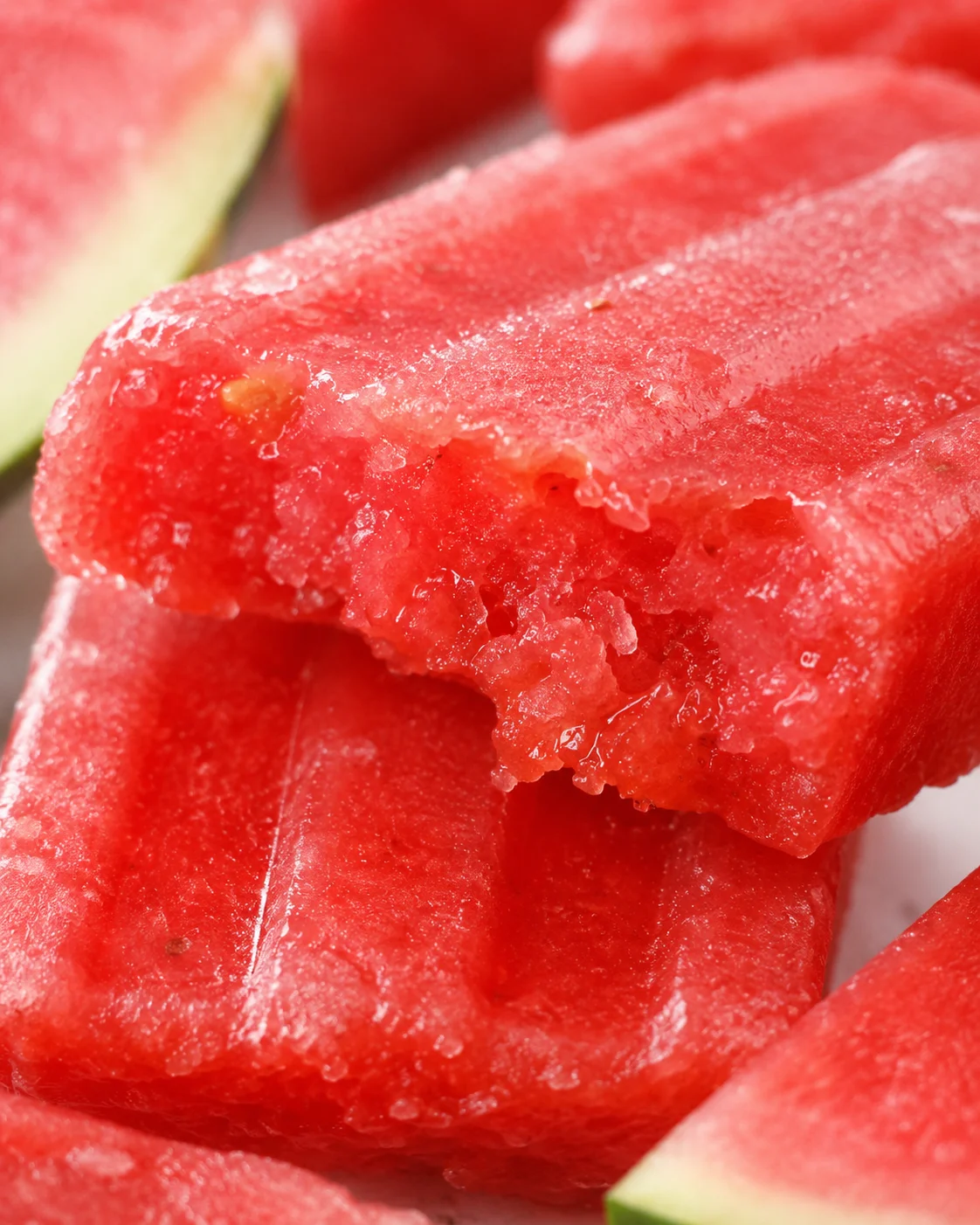 Close-up of vibrant strawberry watermelon ice pops showing their juicy, frozen texture.