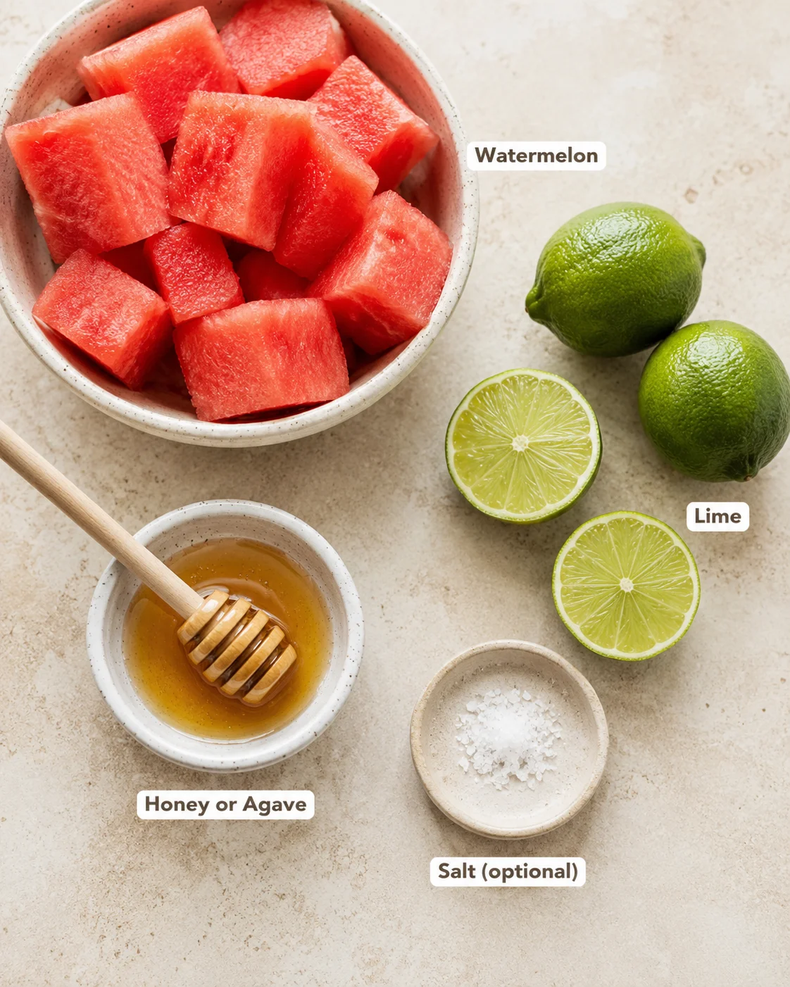 Fresh watermelon cubes, limes, honey, and salt for making popsicles on a beige surface.