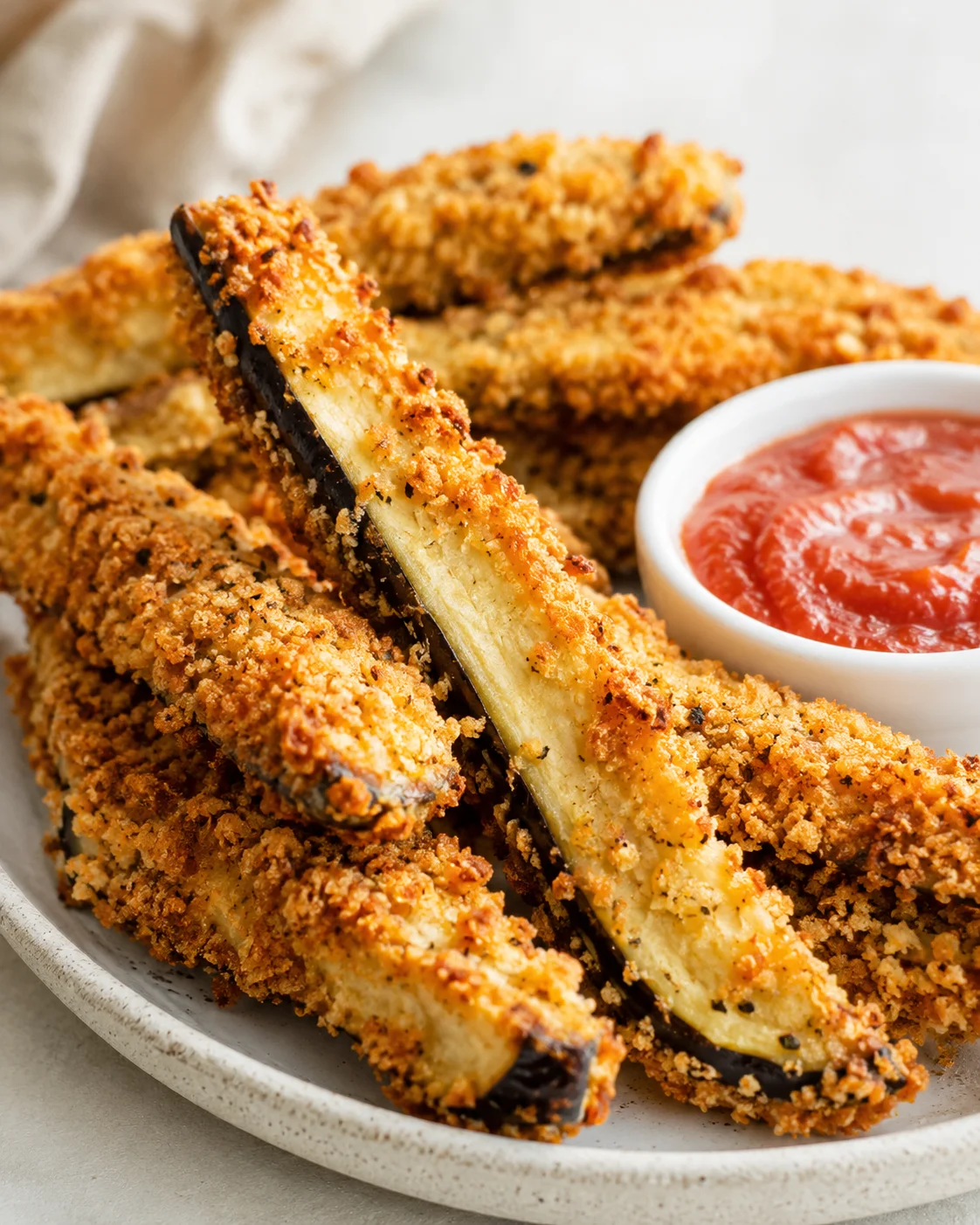Golden, crispy air fryer eggplant fries served with side of marinara sauce.