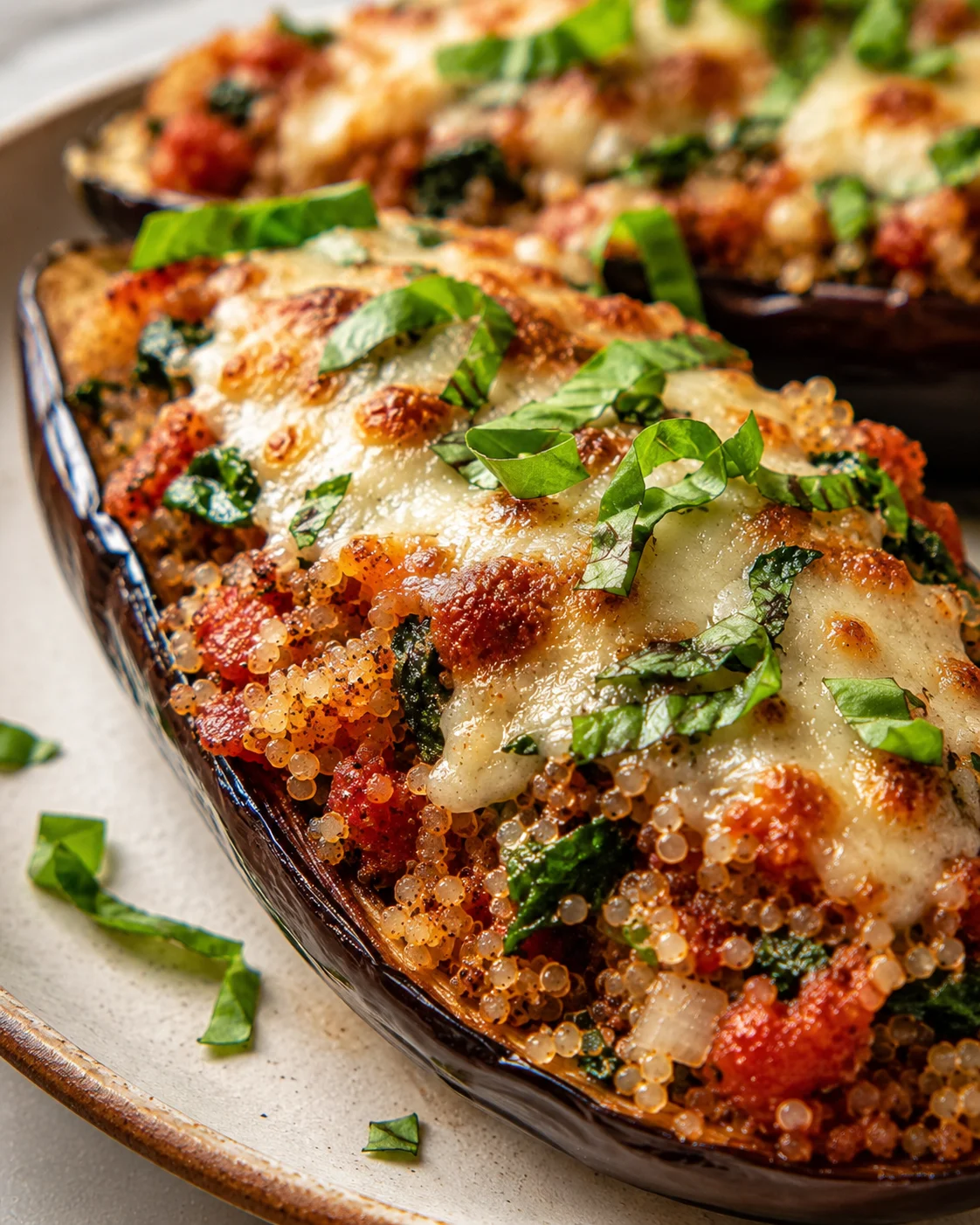 Close-up of baked stuffed eggplant with melted cheese and fresh basil