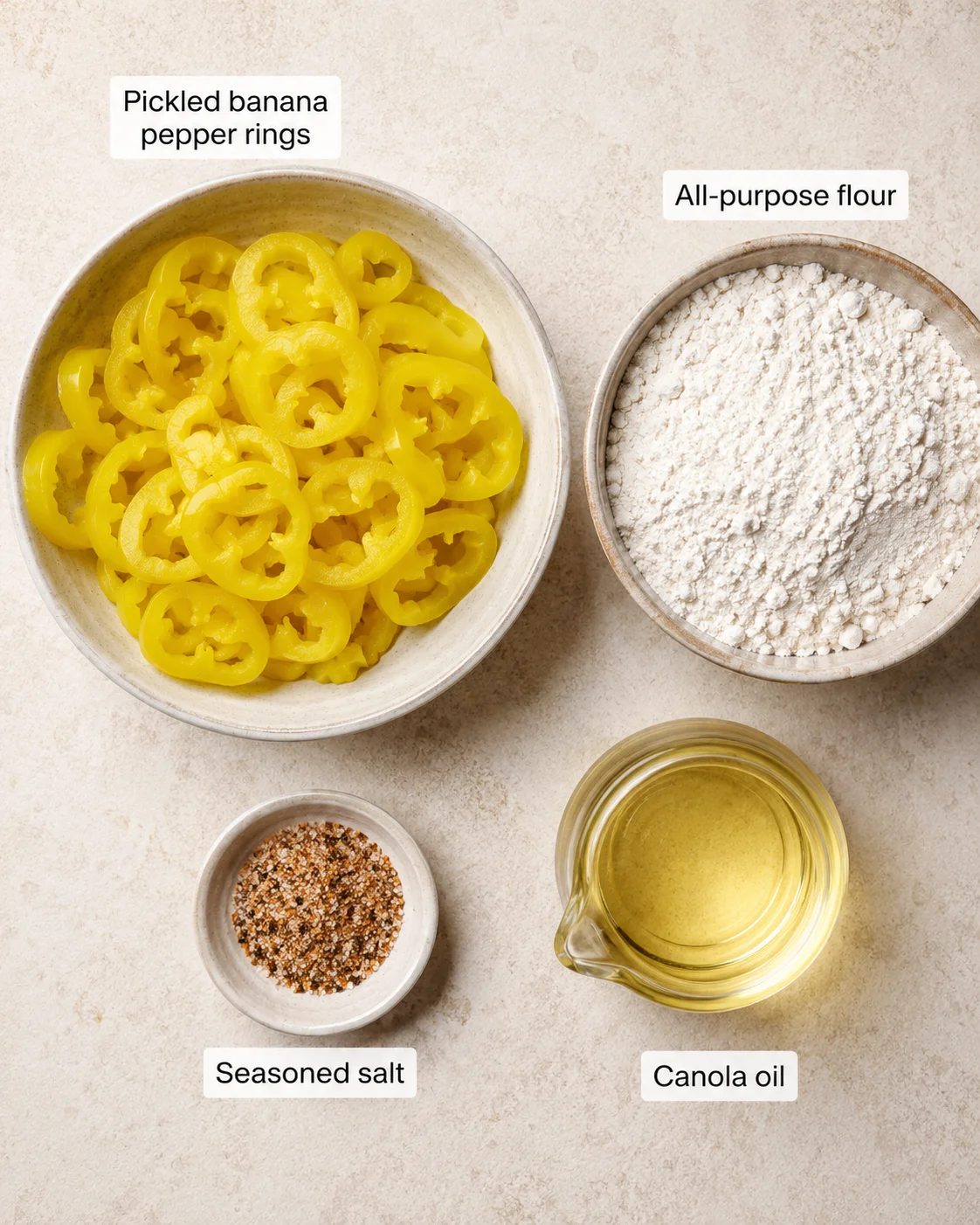 Bowl of pickled banana pepper rings and bowls of flour and seasonings ready for frying.