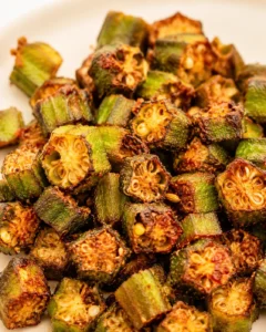 Close-up of crispy, roasted okra slices with charred edges on a white plate
