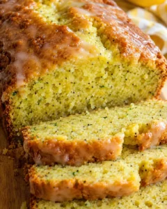 Close-up of moist lemon poppyseed zucchini bread with glaze and poppy seeds