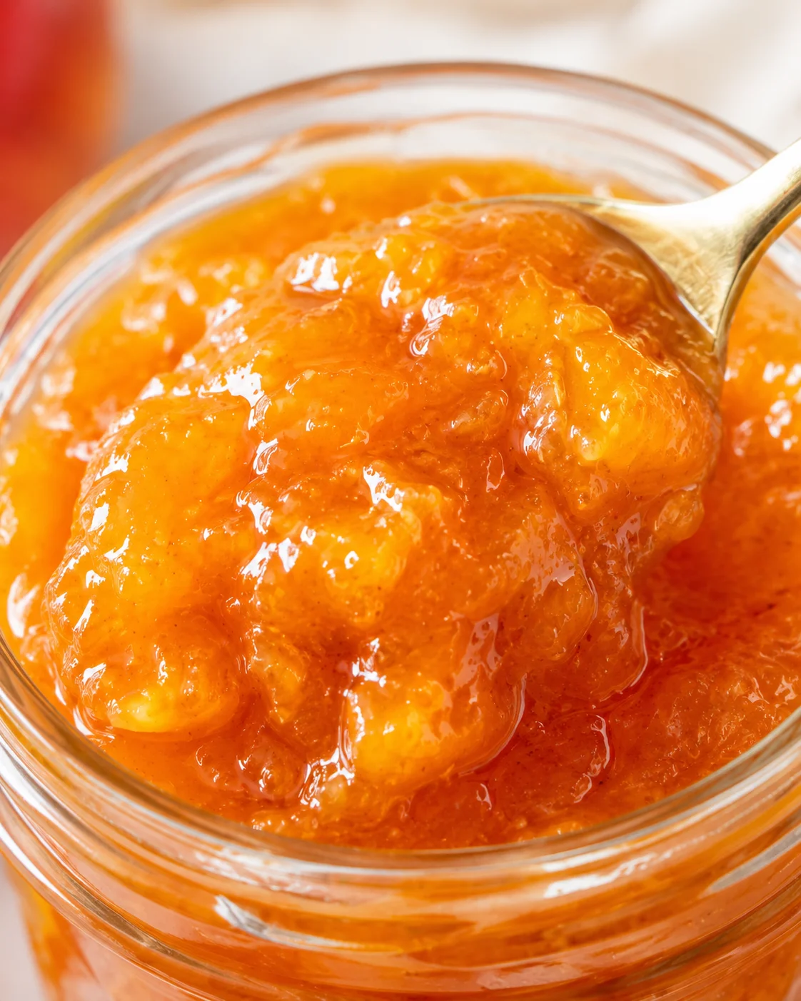 Close-up of vibrant golden nectarines being made into jam with a spoon.