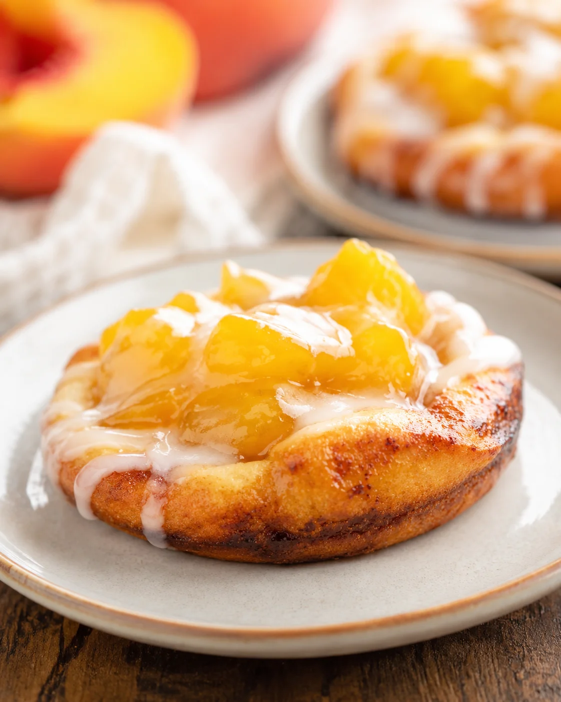 Warm mini peach pies made with cinnamon roll dough and fresh peach filling