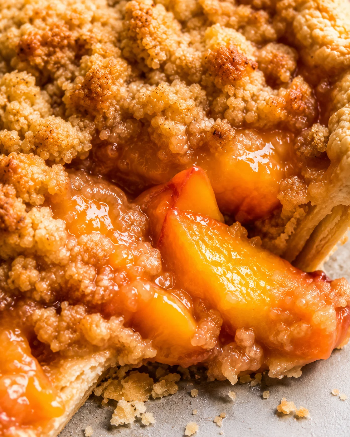 Close-up of warm peach crumble pie topped with buttery crumble