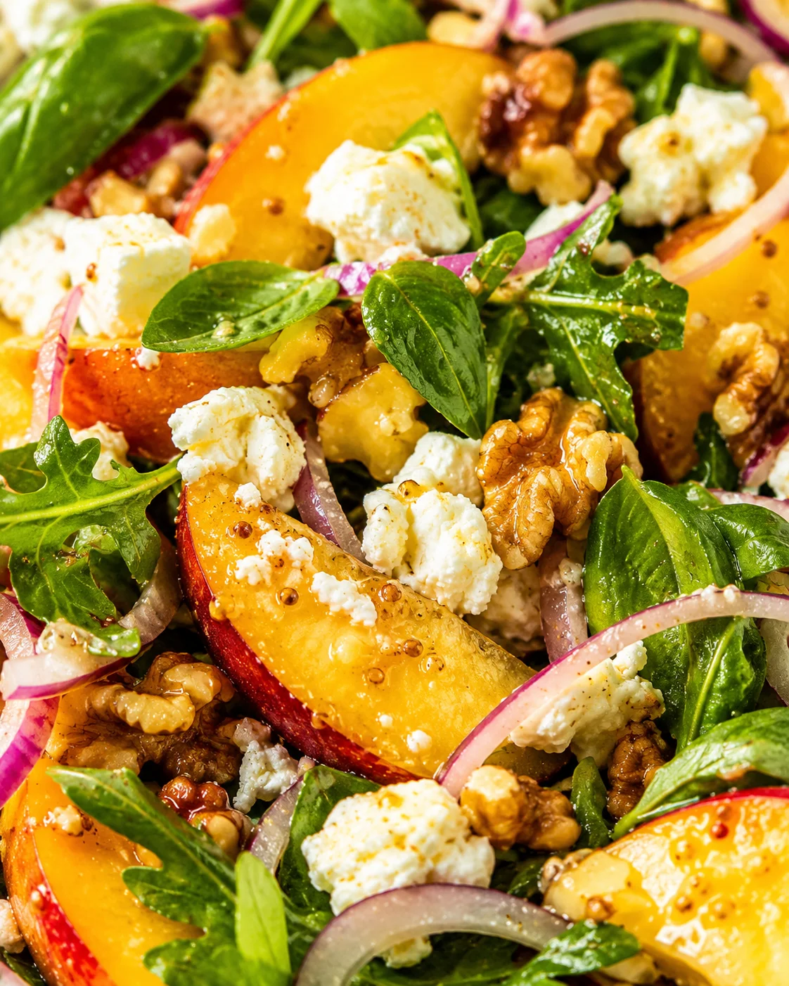 Mediterranean Peach Salad Colorful peach salad with fresh greens, goat cheese, and walnuts