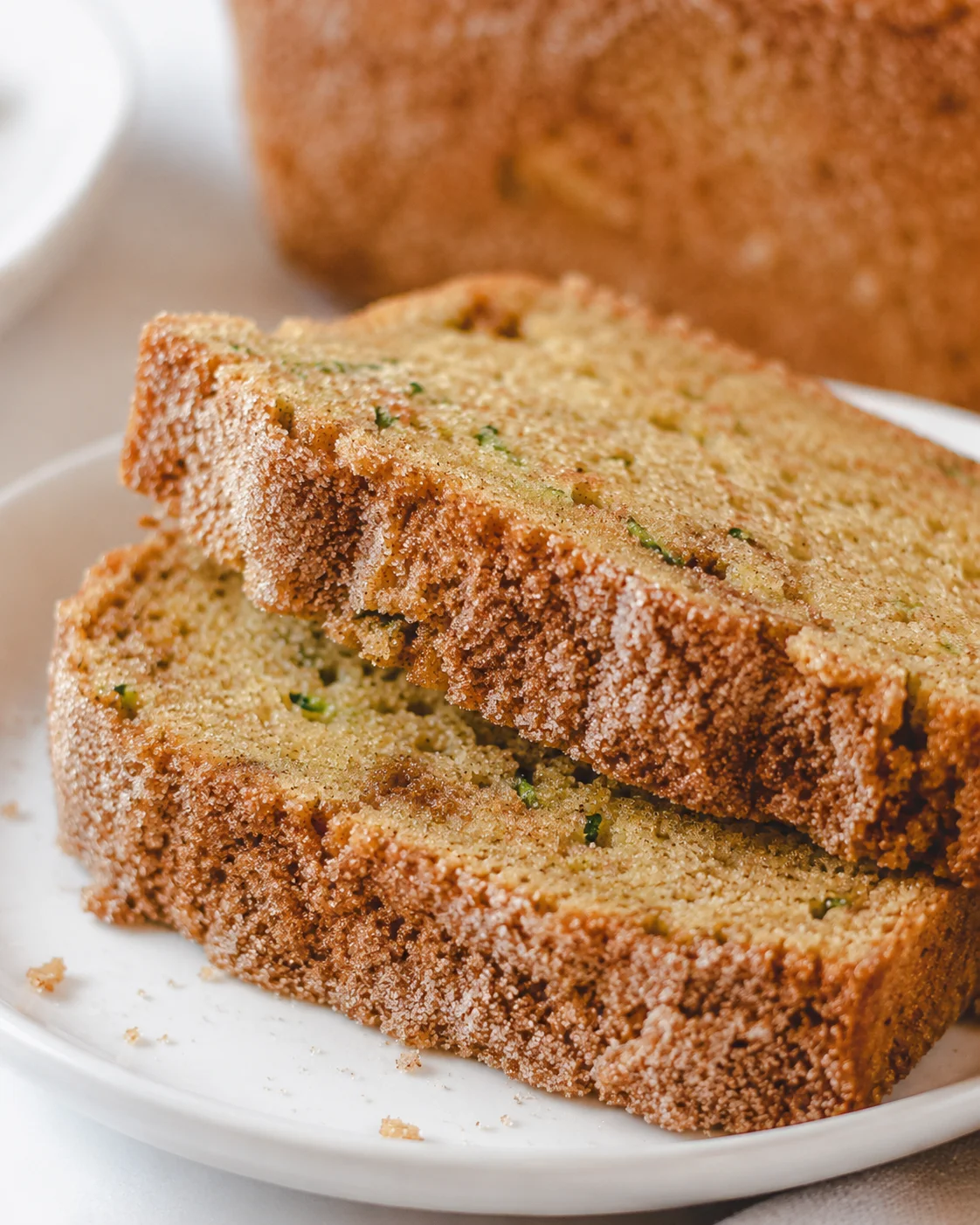 Close-up of sliced snickerdoodle zucchini bread with cinnamon sugar topping.