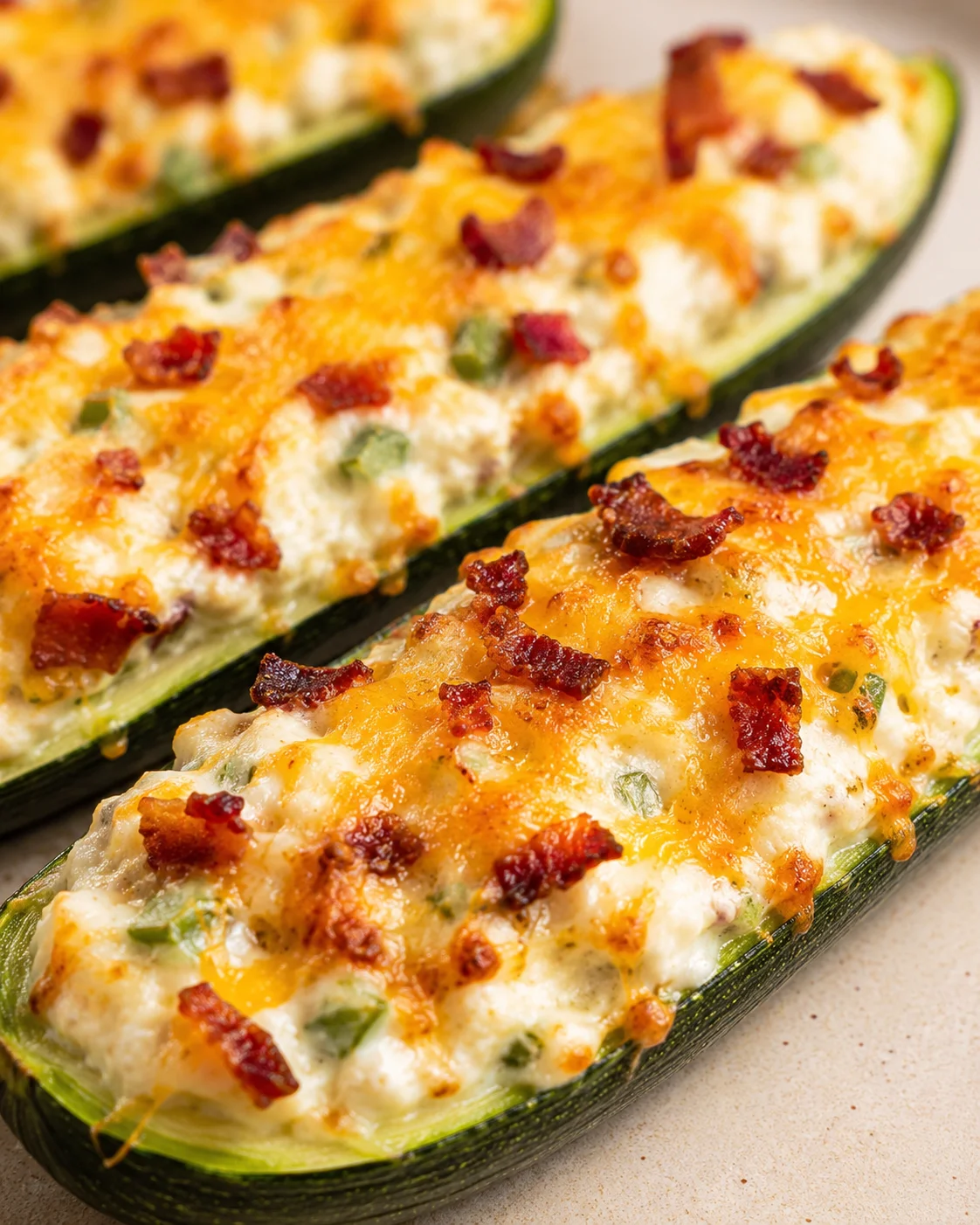 Baked zucchini filled with cheesy, spicy jalapeno and bacon topping.