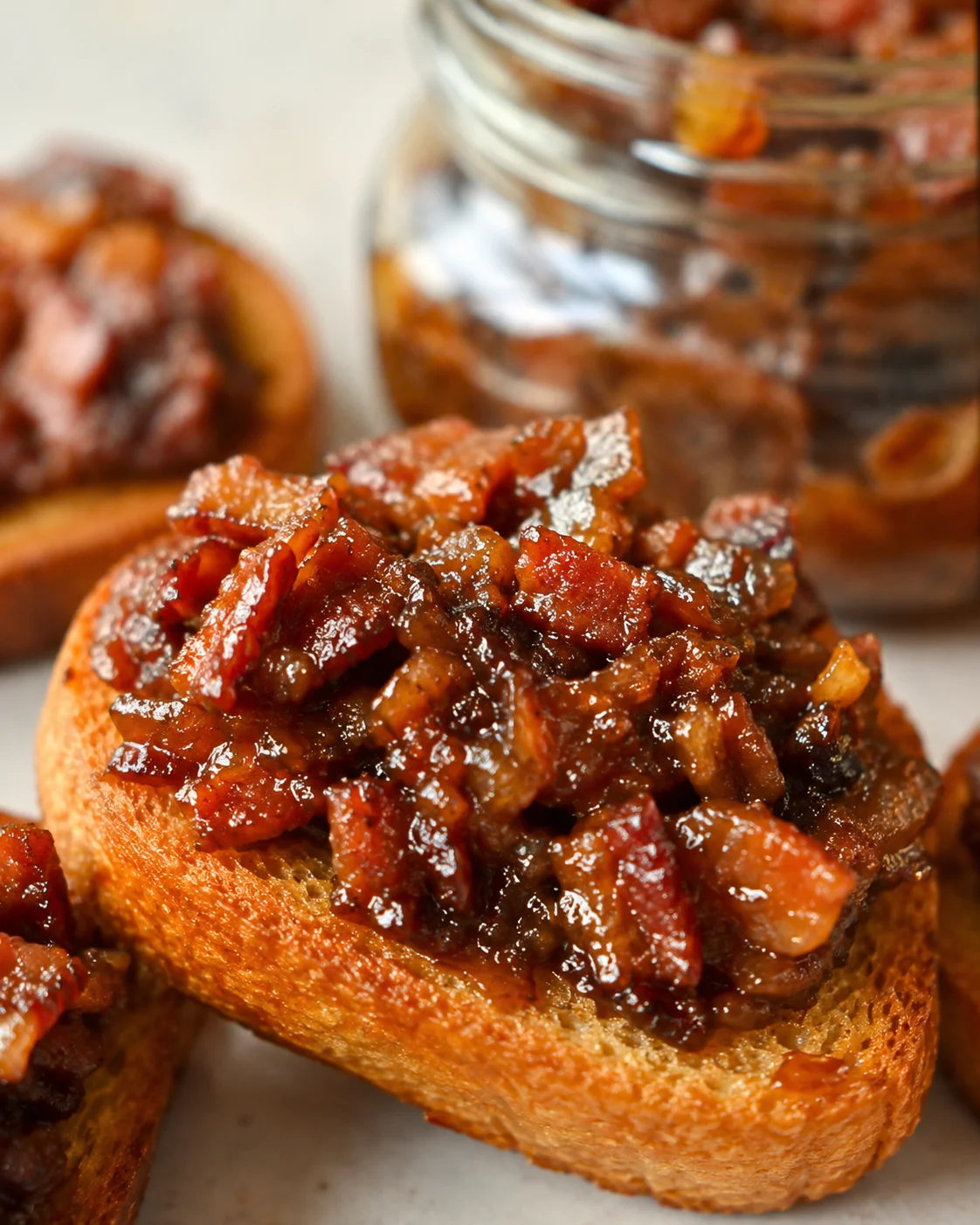 Close-up of toasted bread topped with rich, savory bacon jam.