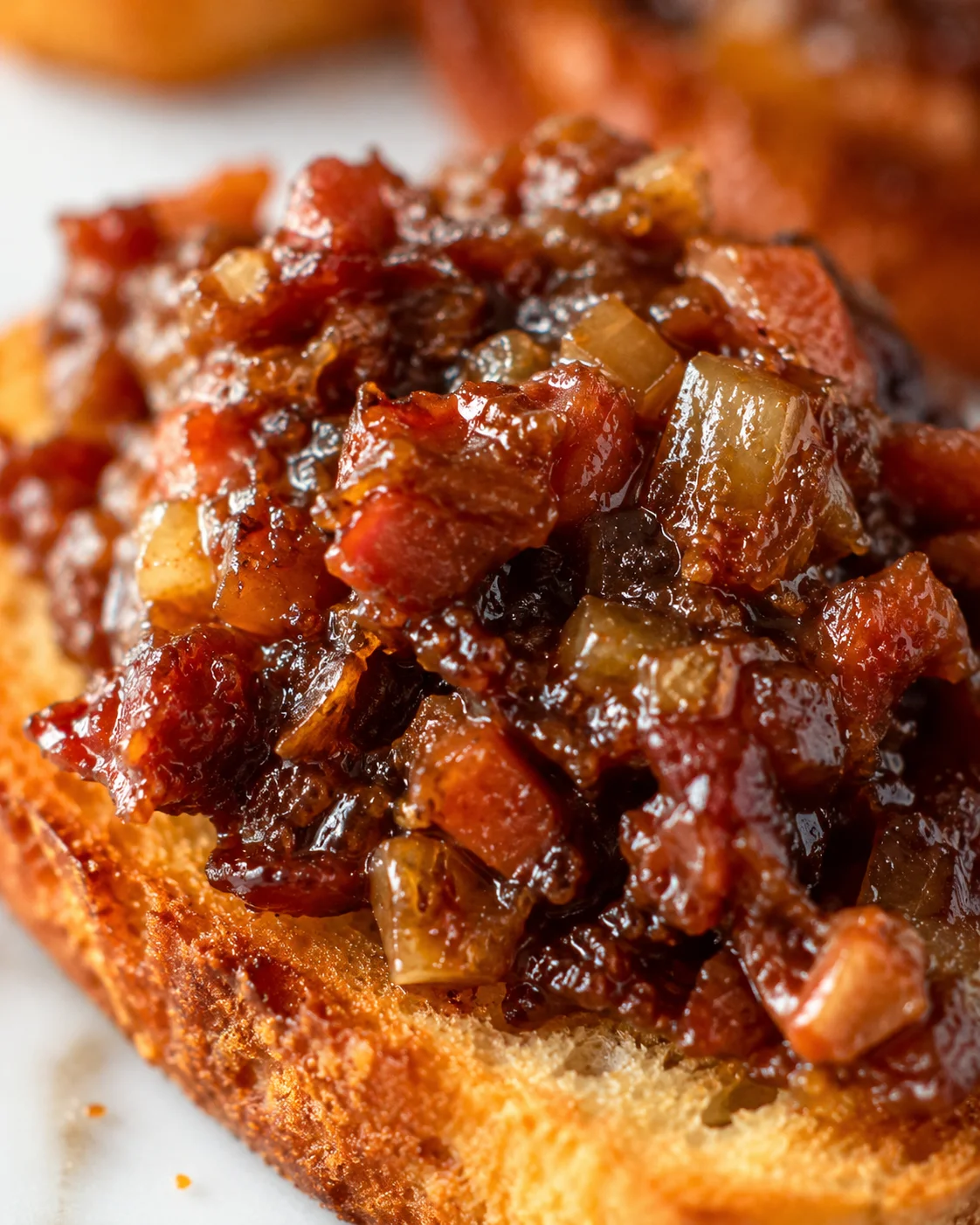 Close-up of a toasted bread topped with rich, homemade bacon jam.