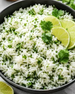 Bowl of cilantro lime rice garnished with lime slices and cilantro
