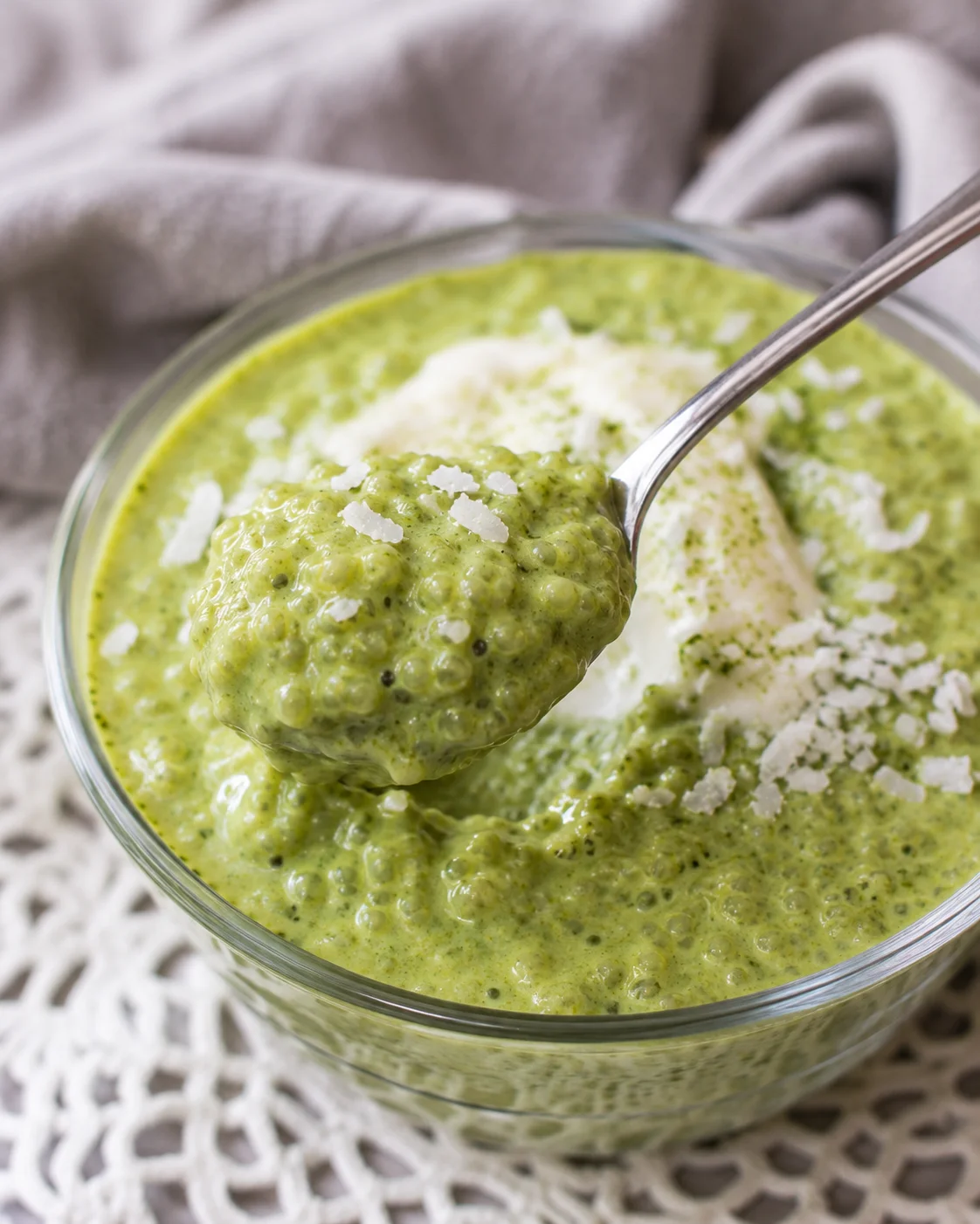 Creamy Matcha Chia Pudding Close-up of vibrant green matcha chia pudding in a glass bowl with a spoon.