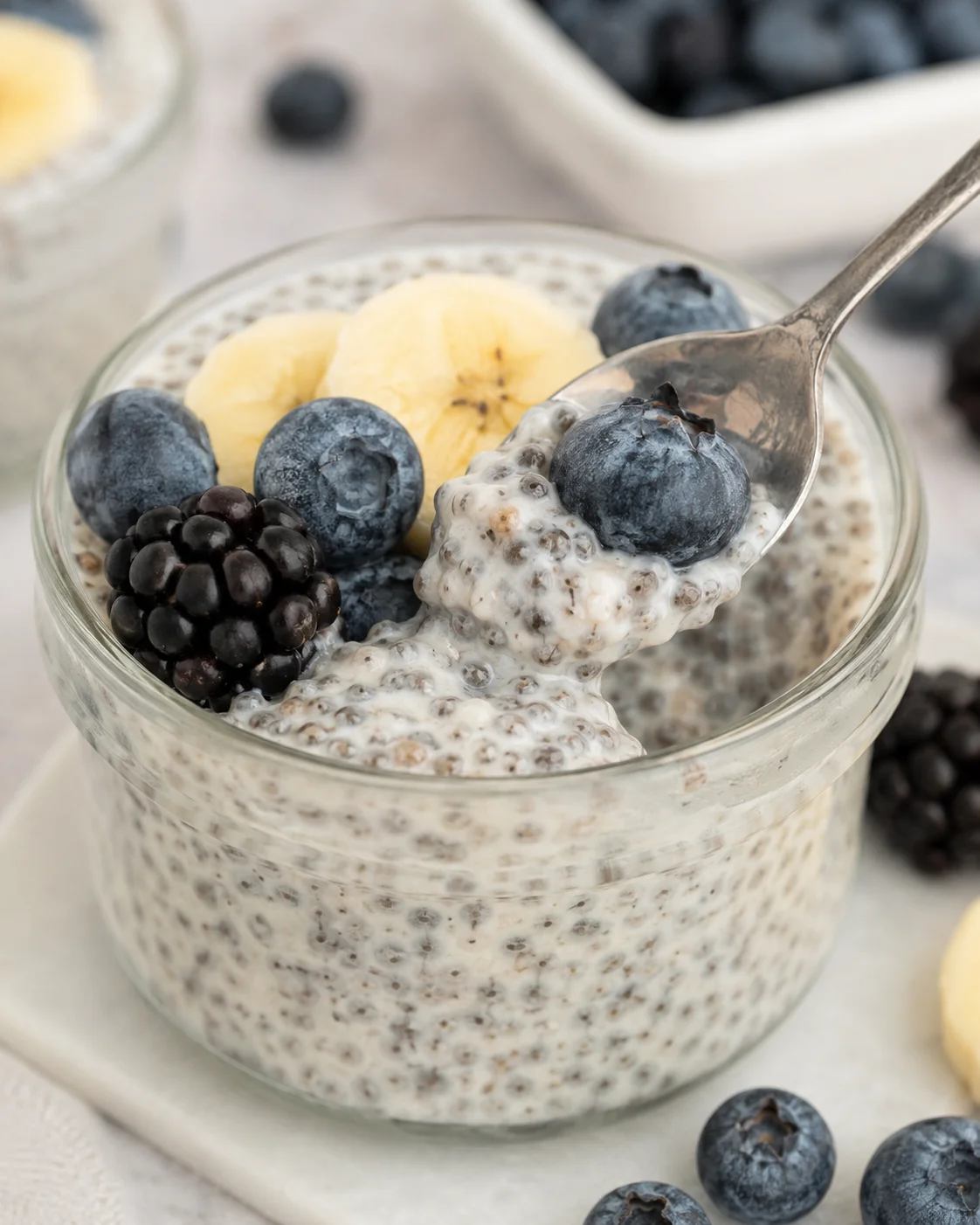 Vanilla Chia Pudding Creamy vanilla chia pudding topped with fresh blueberries and banana slices in a glass.