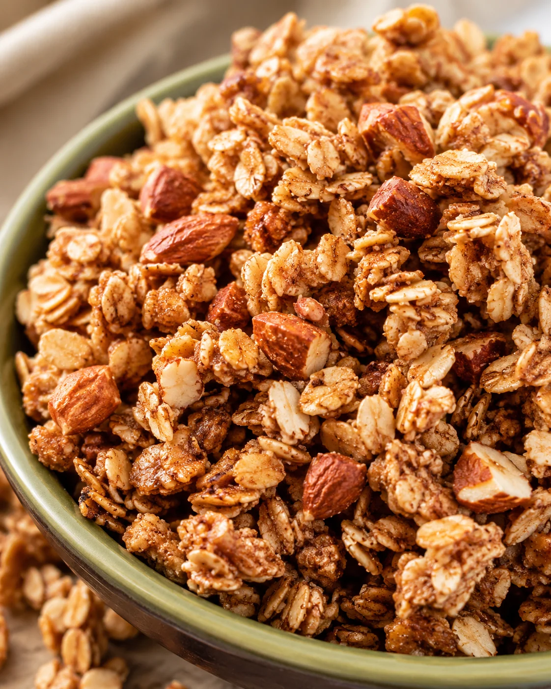 Maple Nut Granola Crunchy homemade maple nut granola with almonds and cinnamon in a bowl