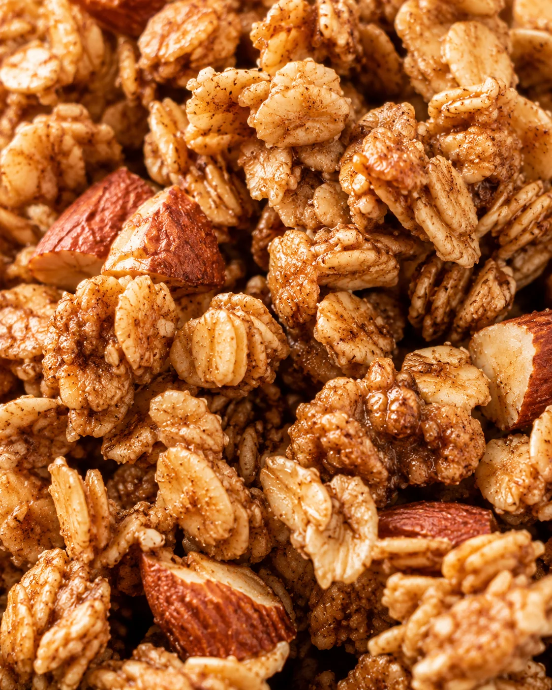 Homemade Maple Nut Granola Close-up of crunchy homemade granola with almonds and cinnamon, coated in maple syrup.