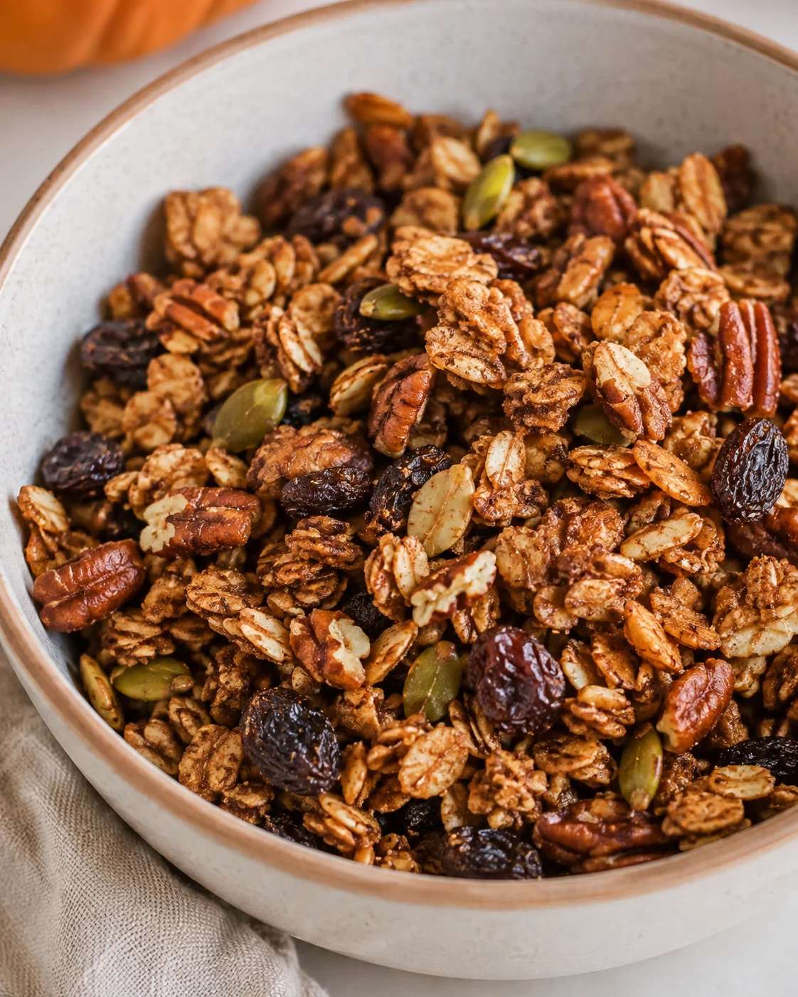 Crunchy homemade pumpkin spice sourdough granola in a bowl, packed with fall flavors