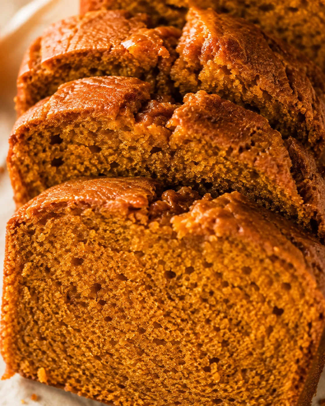 Close-up of several pumpkin bread slices highlighting the moist crumb and glazed crust