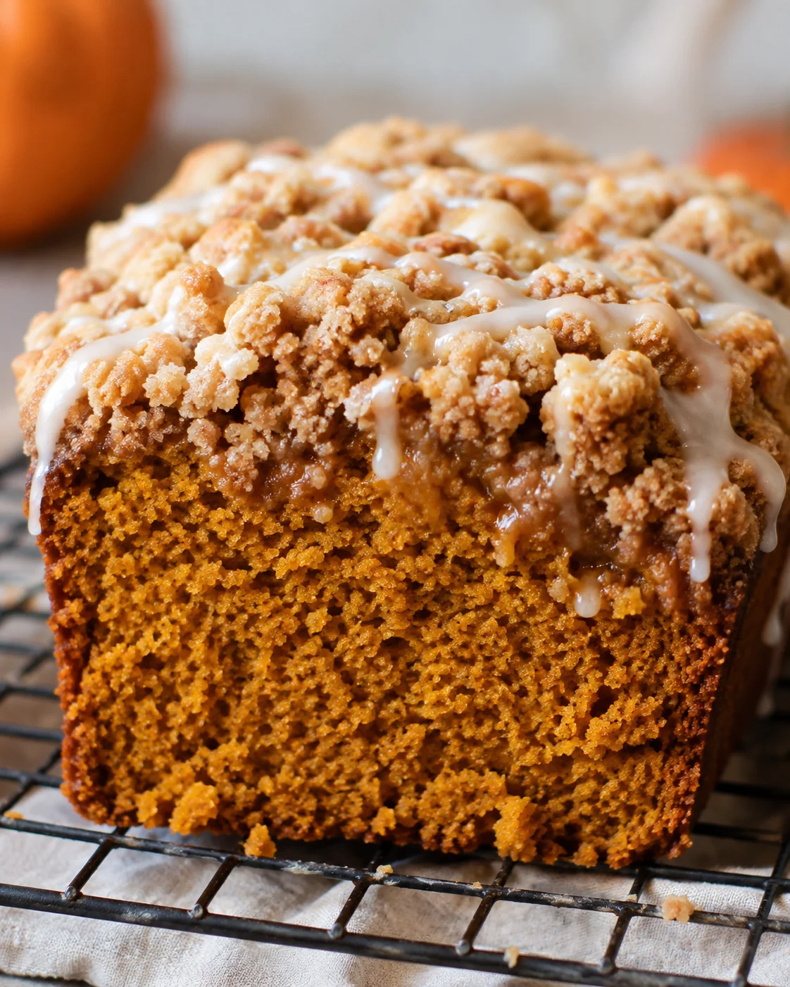 Close-up side view of pumpkin streusel bread showing streusel topping and glaze