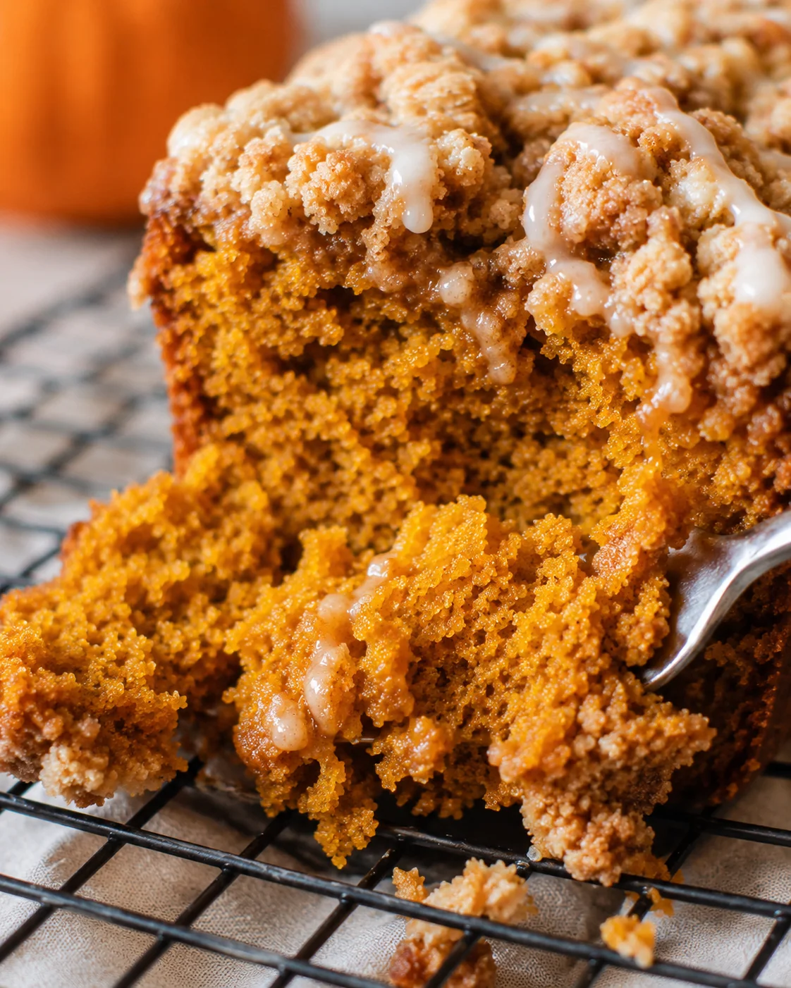 Interior crumb and streusel of pumpkin streusel bread with a fork pulling a piece